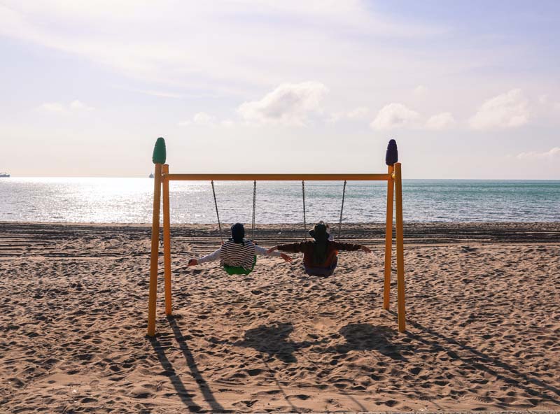 Swinging on playground at Quintana beach